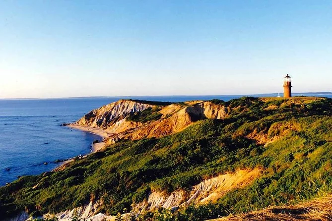 The clay cliffs of Aquinnah in golden light with the red Gay Head lighthouse above