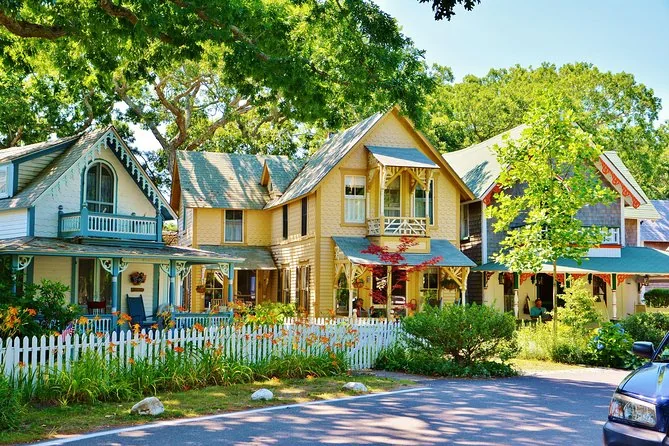 Painted cottages with turquoise trim behind a white picket fence