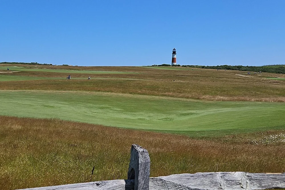 Sankaty Head Lighthouse on the horizon beyond open grassland on Nantucket